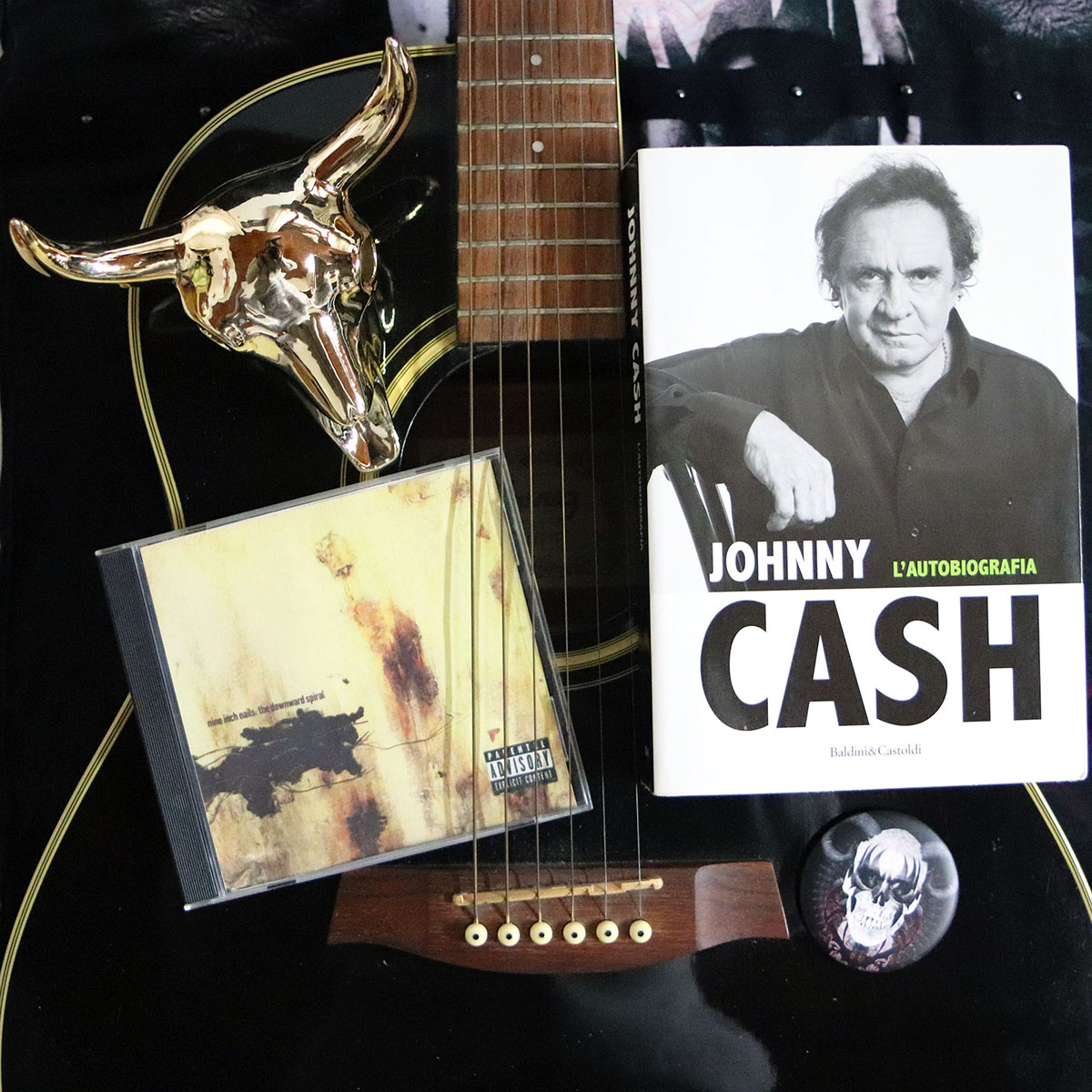 hurt-johnny-cash- autobiografia con cd Nine Inch Nails, chitarra acustica nera e teschio dorato